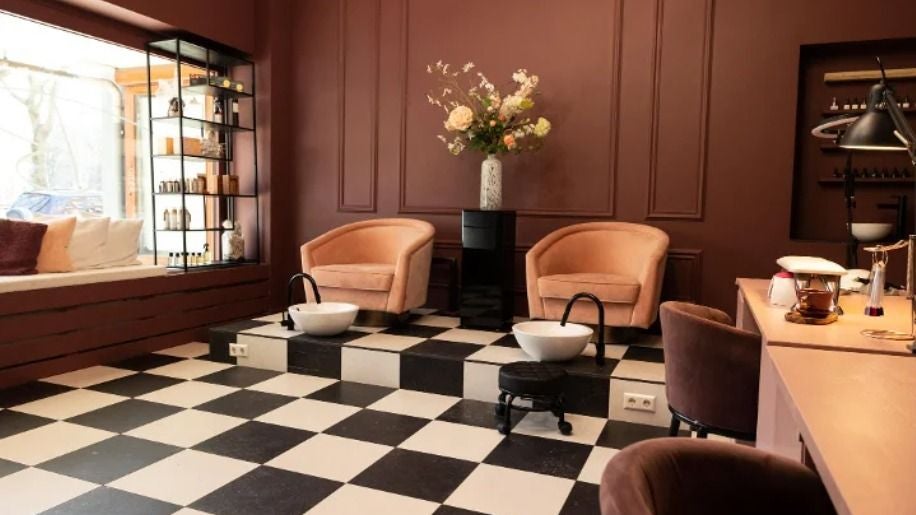 Pedicurestoelen met voetbaden bij het raam, bloemen en een wandkast