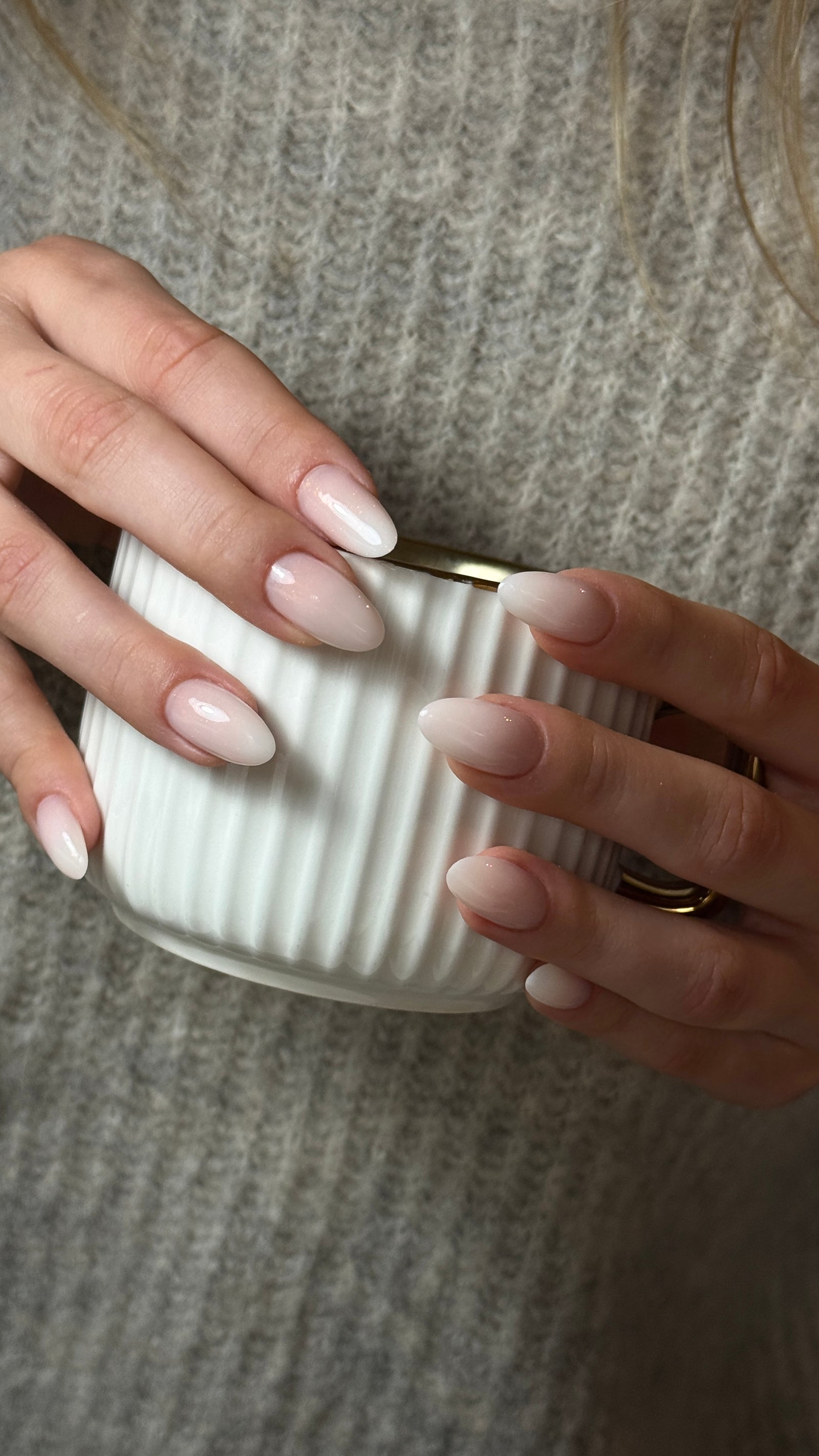 Nude nagels met een zachte ombre rond een witte beker